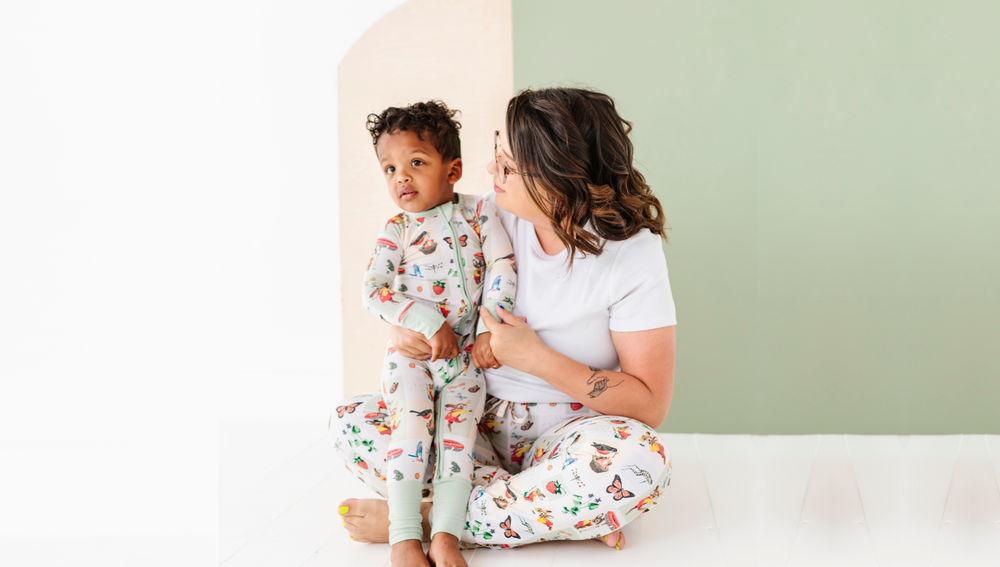 Mom and toddler sitting together in matching Richard Scarry's I Am A Bunny Sunny Days pajamas